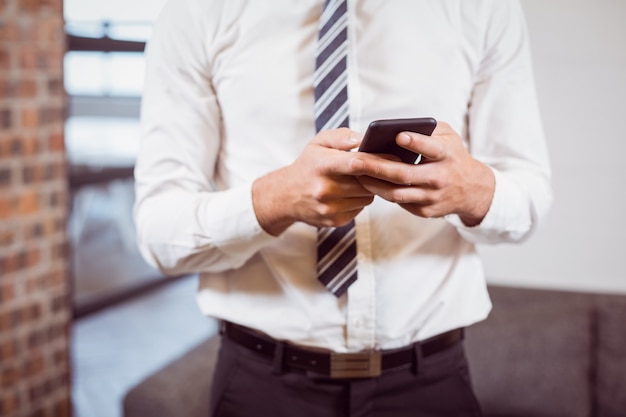 Midsection of businessman using smartphone 