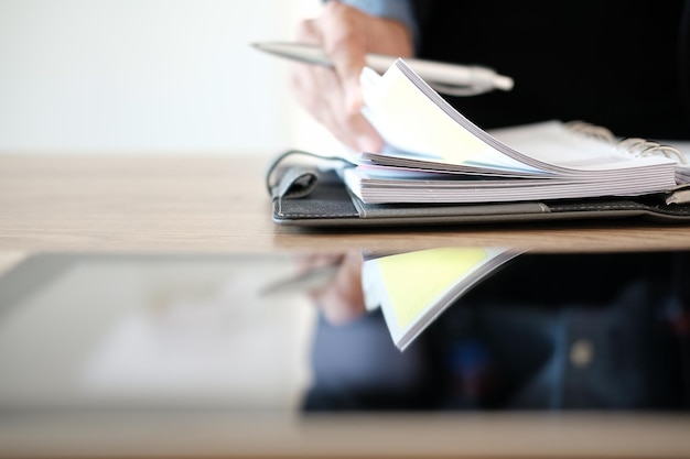 Photo midsection of businessman with book at desk in office