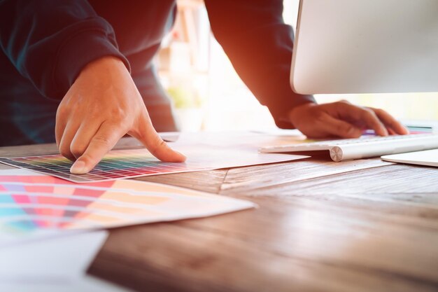 Photo midsection of businessman with color swatches on desk in office