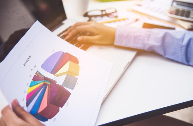 Photo midsection of businessman working over graph on table in office