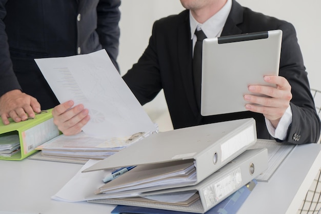 Midsection of businessmen at desk in office