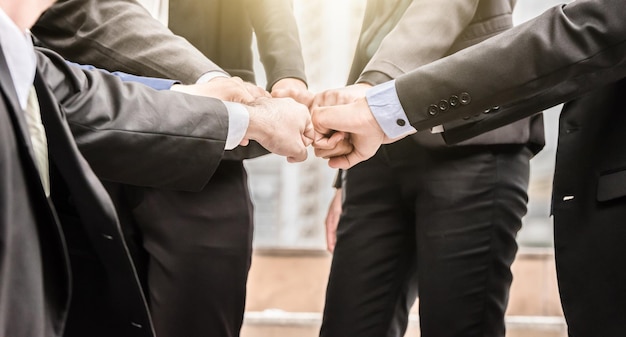 Midsection of businessmen with clenching fists standing in city