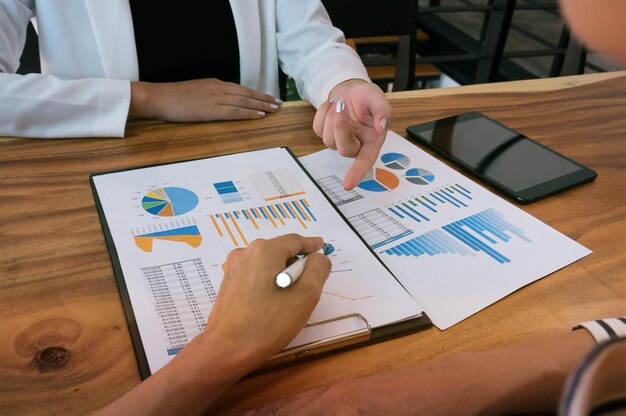 Midsection of businesswoman pointing at document to colleague in office