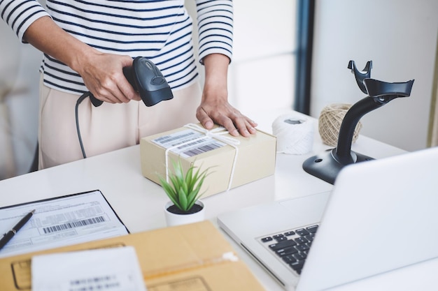 midsection of businesswoman scanning bar code in office