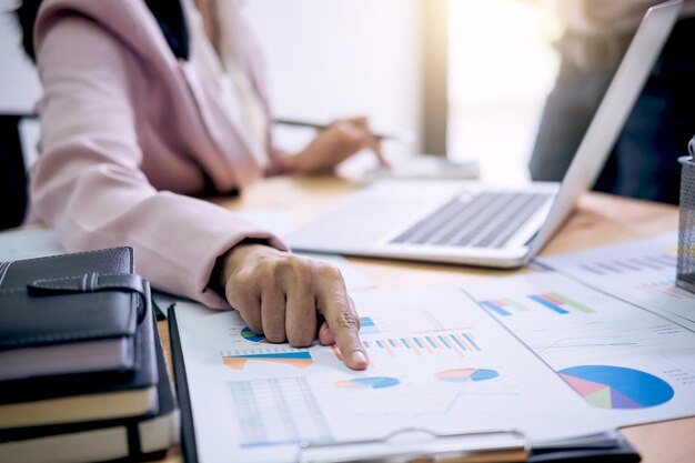 Midsection of businesswoman using laptop on table