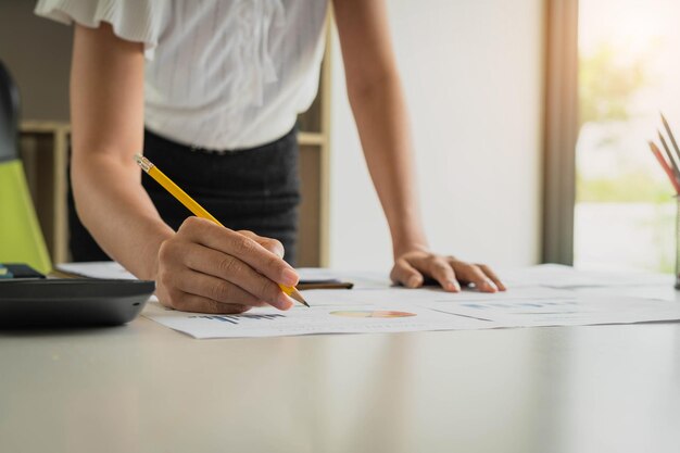 Midsection of businesswoman working in graph at office