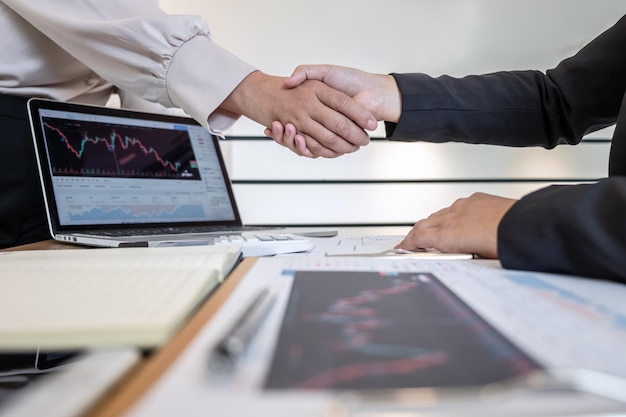 Midsection of businesswomen shaking hands on table