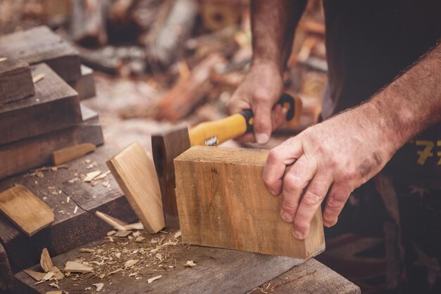 Foto sezione centrale di un falegname che taglia il legno in officina