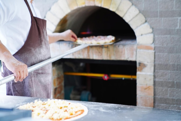 Sezione centrale dello chef che prepara la pizza nella cucina del ristorante