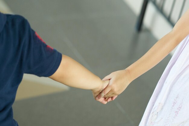 Foto sezione centrale di una coppia di bambini che si tengono per mano