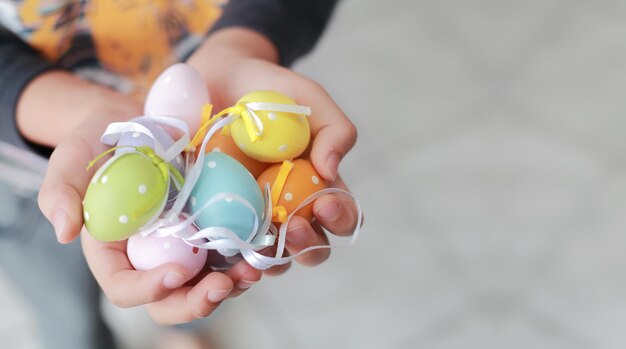 Midsection of child holding colorful balloons