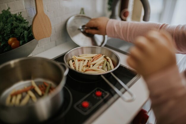 Foto sezione centrale di un bambino che prepara il cibo a casa