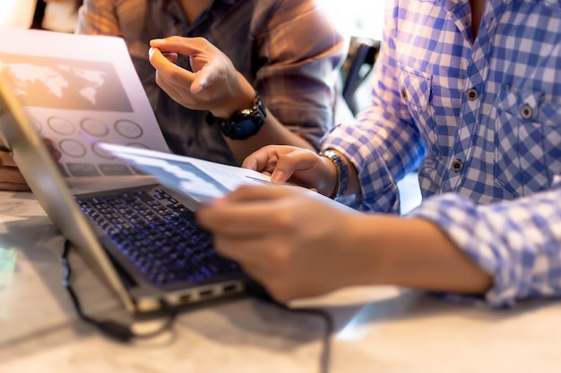 Photo midsection of colleague analyzing graphs by laptop on office desk