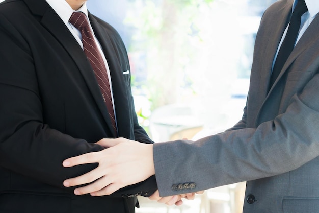 Midsection of colleagues shaking hands in city