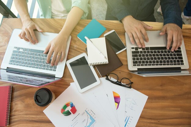 Photo midsection of colleagues working on desk in office