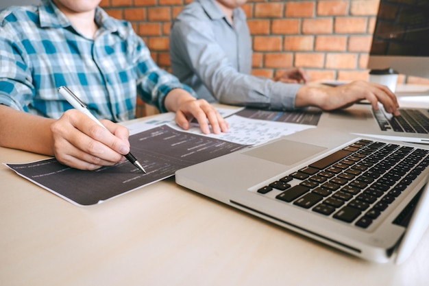 Photo midsection of colleagues working at desk in office