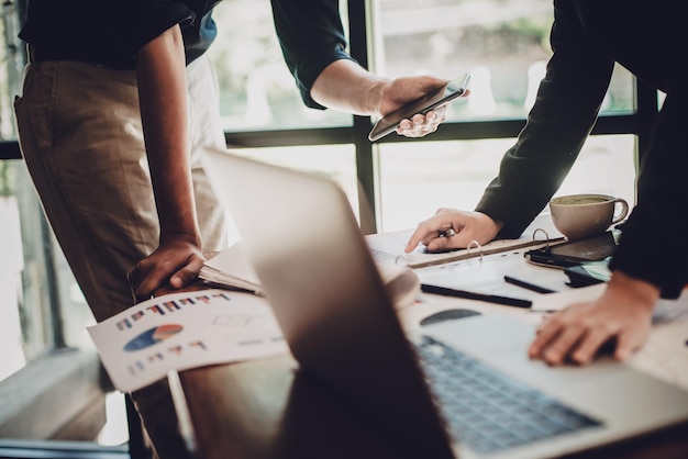 Photo midsection of colleagues working at desk in office