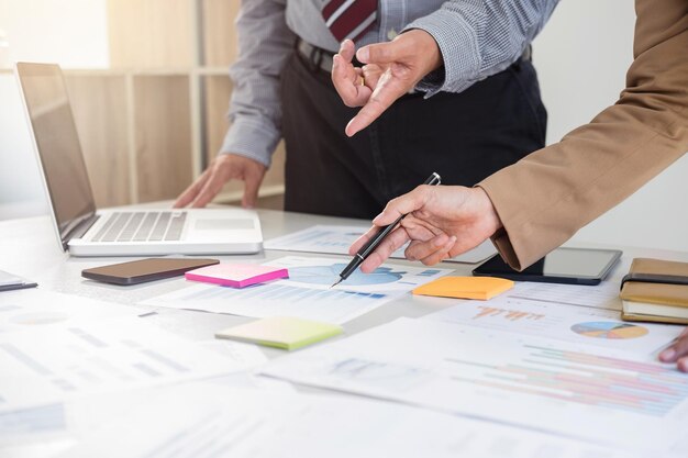 Midsection of colleagues working at desk in office