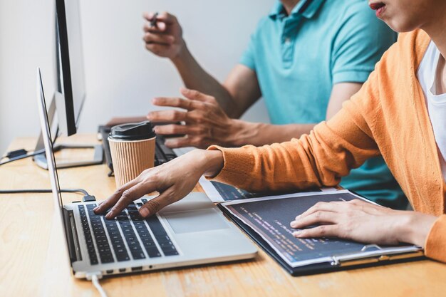 Photo midsection of computer programmers using laptop on desk