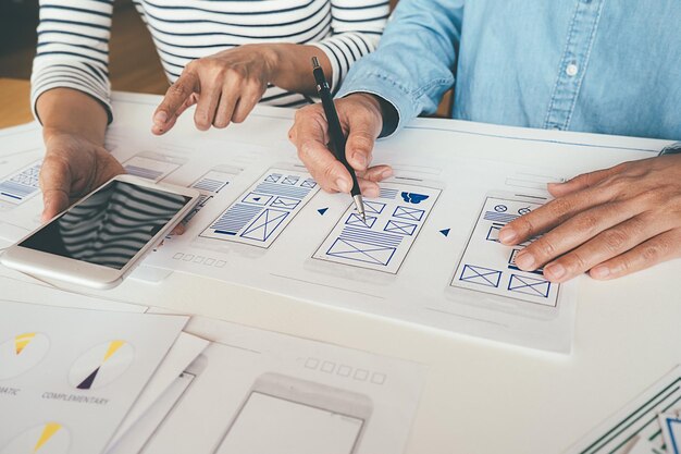 Photo midsection of computer programmers working on table