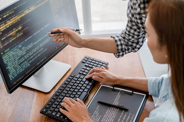 Photo midsection of computer programmers working on table