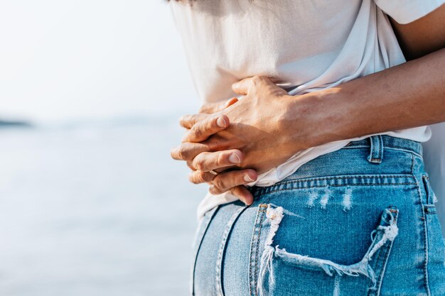 Midsection of couple embracing at beach