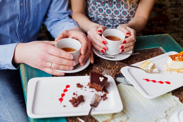 Foto sezione centrale di una coppia che beve caffè e dessert in un ristorante