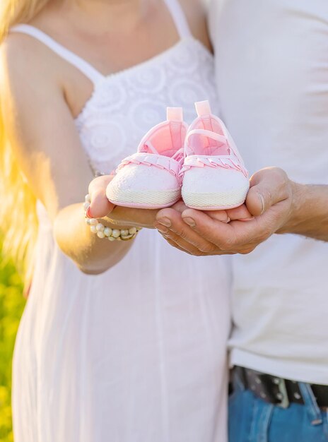 Foto sezione centrale di una coppia che tiene le scarpe per bambini