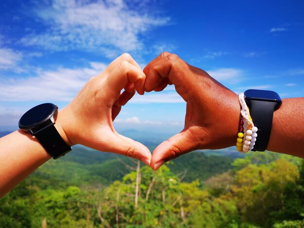 Photo midsection of couple holding hands against sky