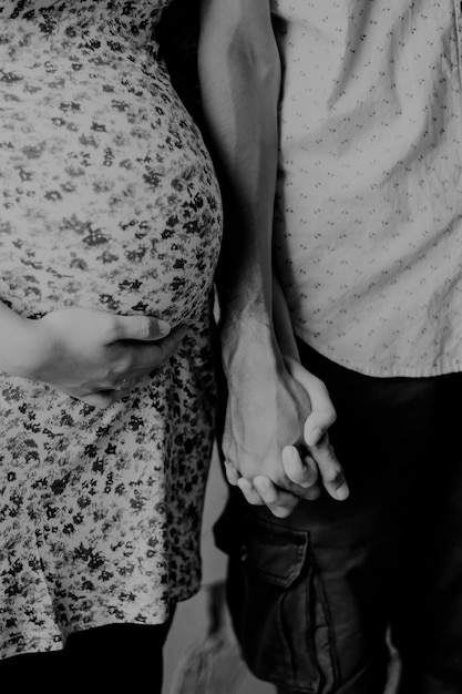 Midsection of couple holding hands at home