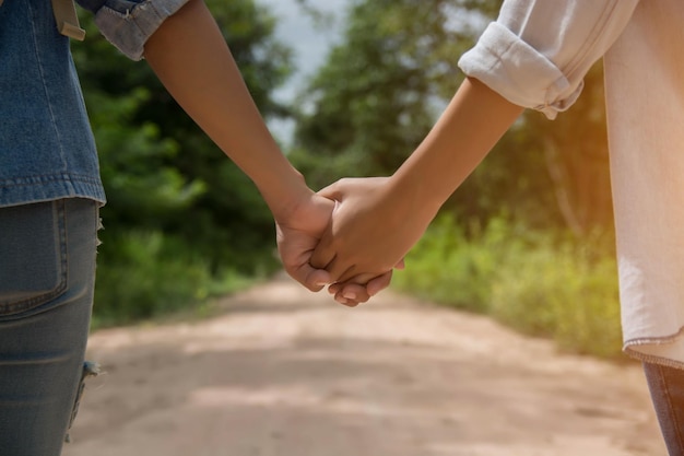 Midsection of couple holding hands outdoors