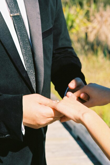 Photo midsection of couple holding hands while standing outdoors