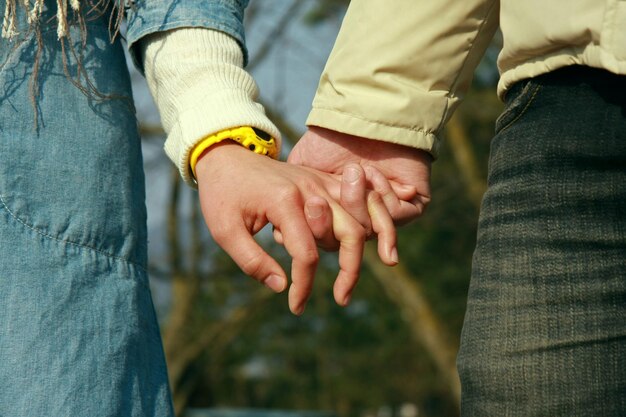 Midsection of couple holding hands