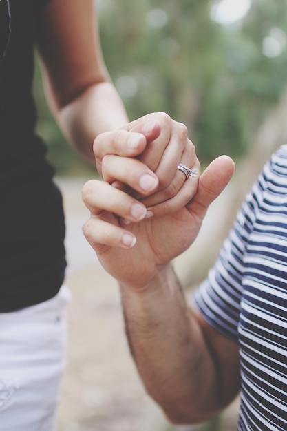 midsection of couple holding hands