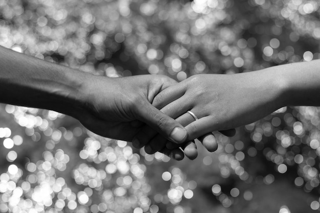 midsection of couple holding hands
