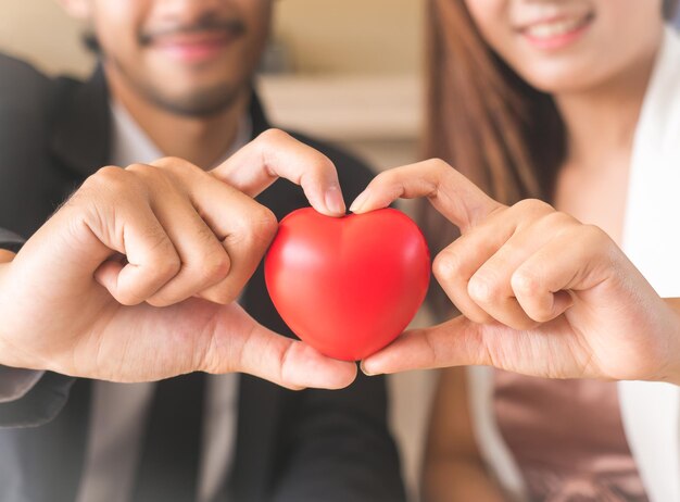 Photo midsection of couple holding heart shape at home