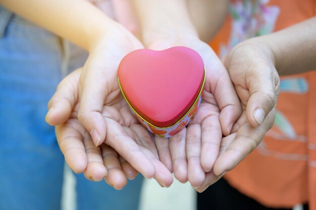 Photo midsection of couple holding heart shaped box