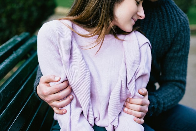 Photo midsection of couple romancing on park bench