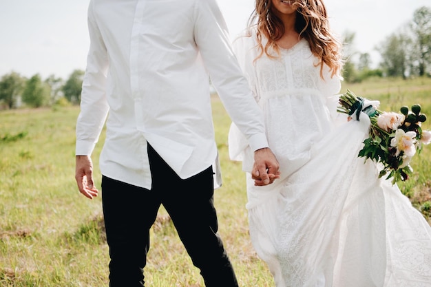 Photo midsection of couple with holding hands walking on field