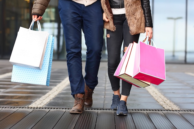 Midsection of couple with shopping bags in city