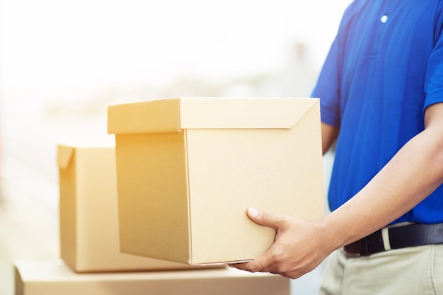 Midsection of delivery person holding cardboard box