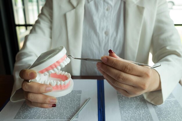 Photo midsection of dentist holding dentures on table