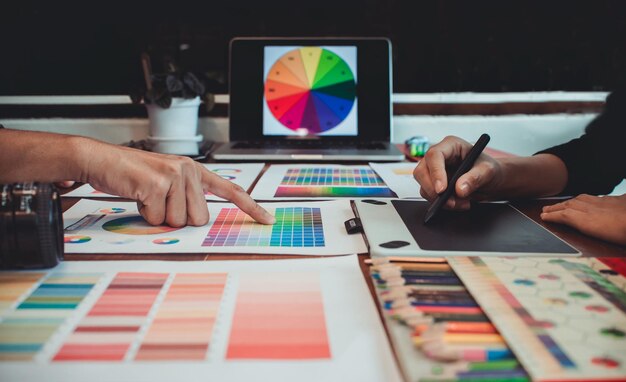 Foto sezione centrale di professionisti della progettazione che lavorano su campioni di colore sul tavolo