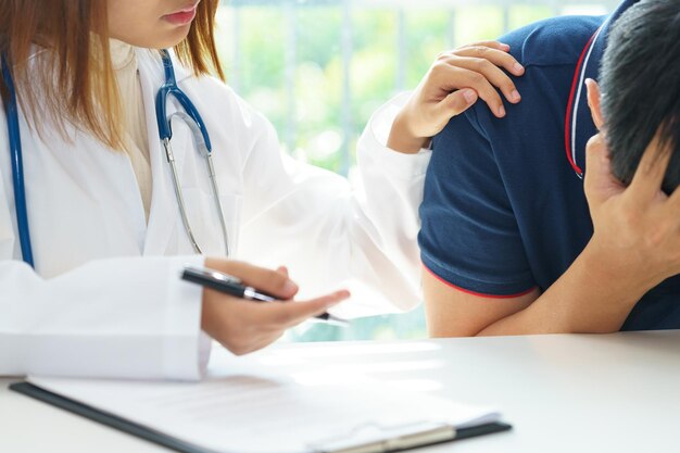 Photo midsection of doctor consoling worried patient at hospital