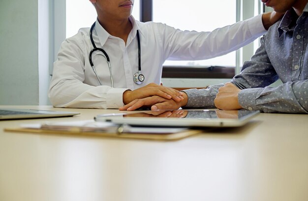 Photo midsection of doctor examining patient in hospital