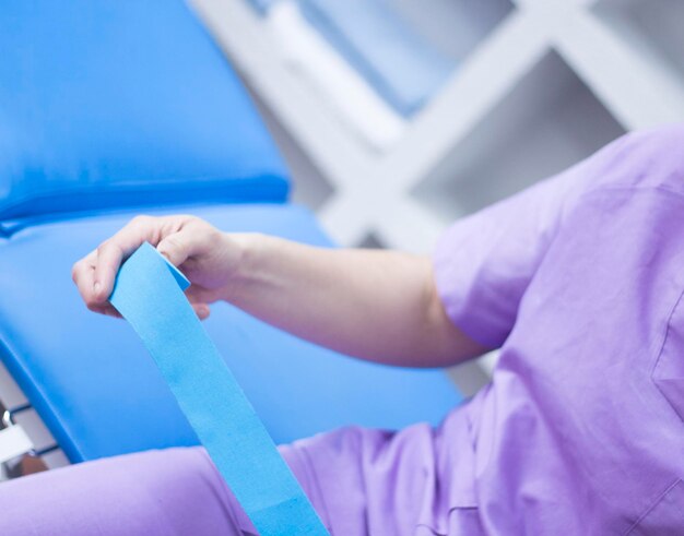 Midsection of doctor holding bandage in hospital