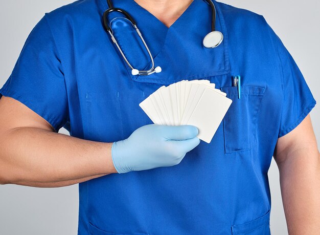 Midsection of doctor holding cards while standing against white background