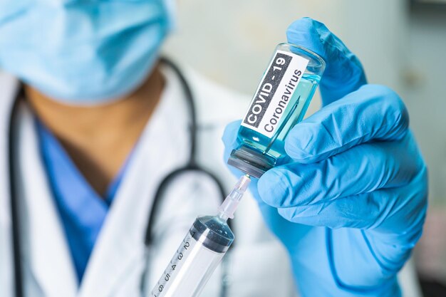 Photo midsection of doctor holding syringe