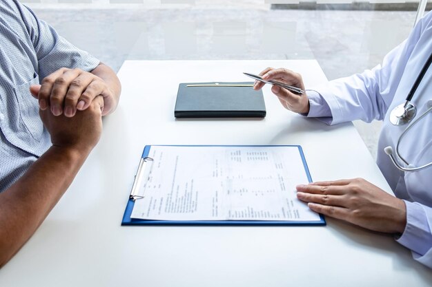 Photo midsection of doctor and patient discussing on table