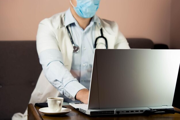 Photo midsection of doctor using laptop at clinic